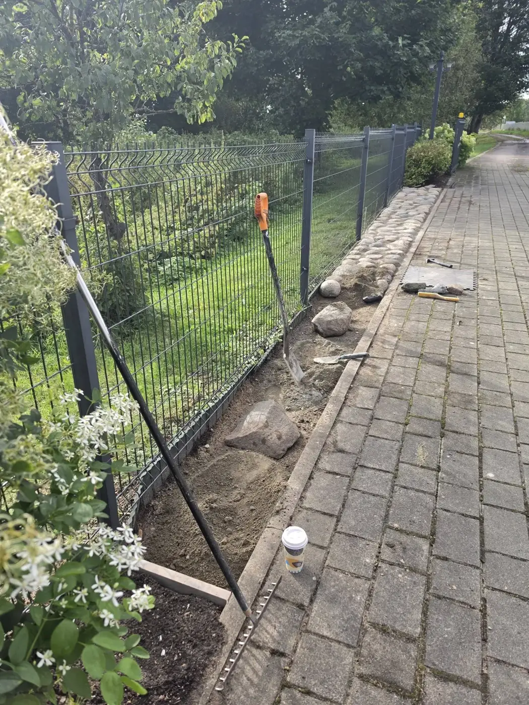 Darbų metu: iškastas ruožas palei tvorą, paruoštas akmenims